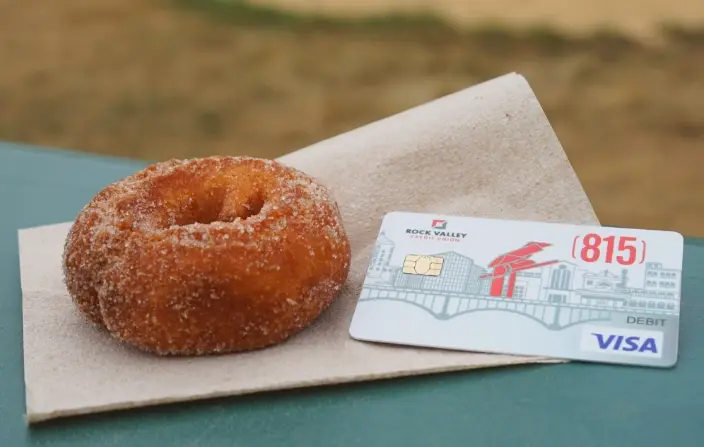 815 debit card sitting next to donut