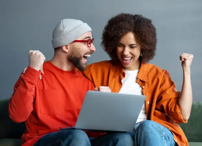 couple celebrating at computer